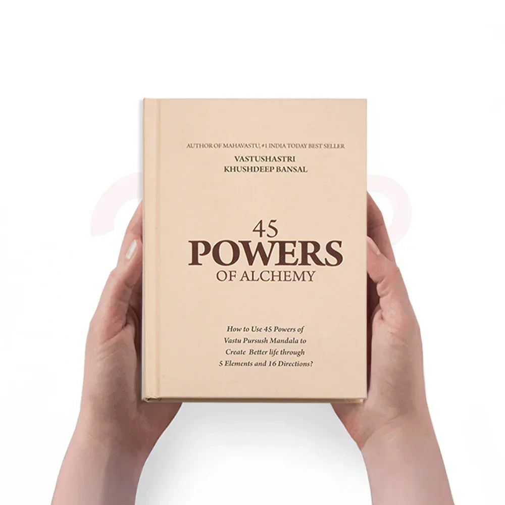 Hands holding the book '45 Powers of Alchemy' for Vastu Shastra remedies