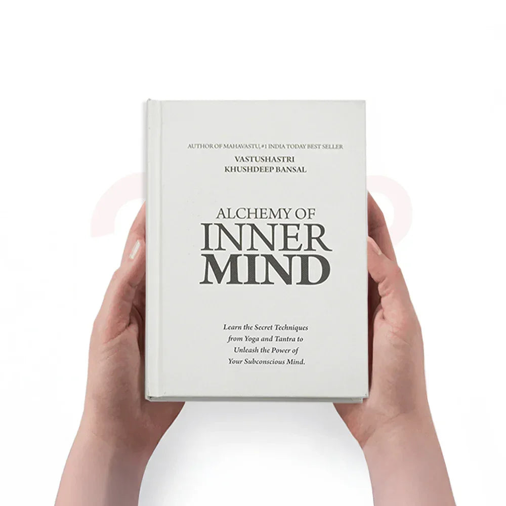 Hands holding the book 'Alchemy of Inner Mind' on white background, MahaVastu remedy guide