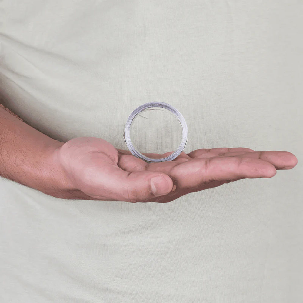 Hand holding coiled silver Vastu metal strip for home energy balance and positive vibes