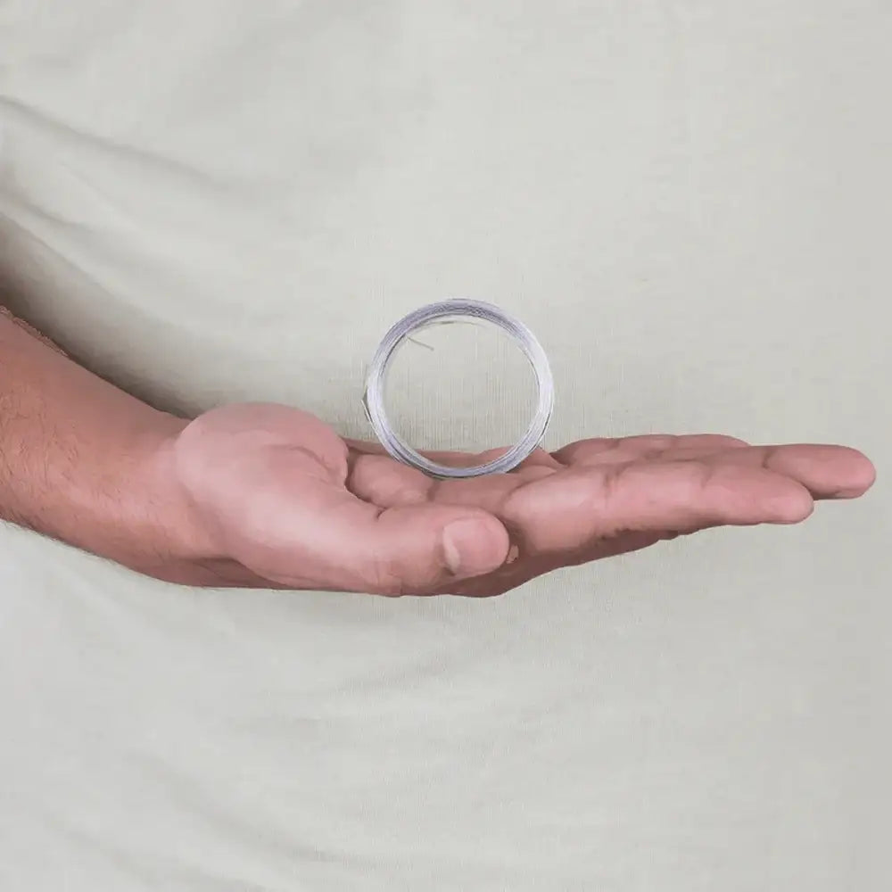 Hand holding coiled silver Vastu metal strip for home energy balance and positive vibes