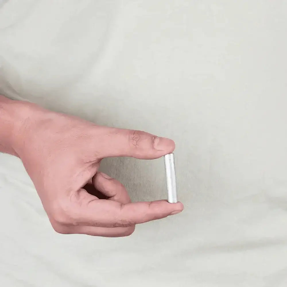 Hand holding small silver metal strip for Vastu remedies and home energy balance