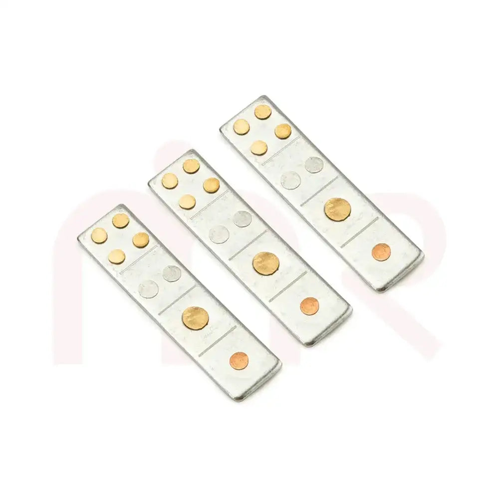 Three silver metal strips with embedded brass and copper dots for Vastu remedies.