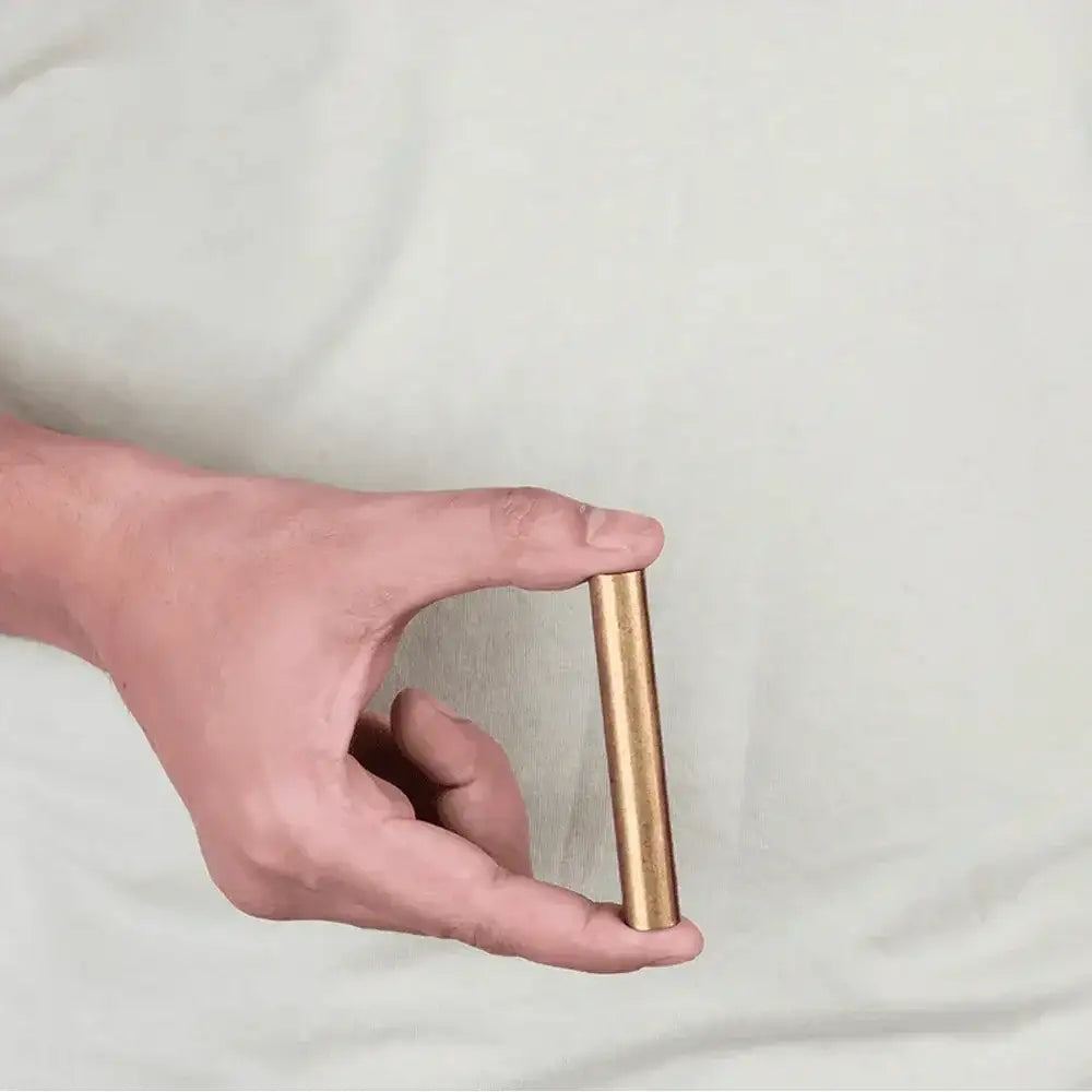 Hand holding a brass Vastu metal strip for home energy balance and positivity