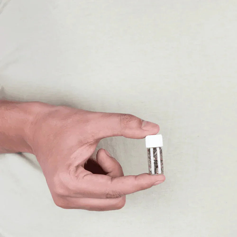 Hand holding a small MahaVastu Cat's Eye remedy bottle for Vastu Shastra balance