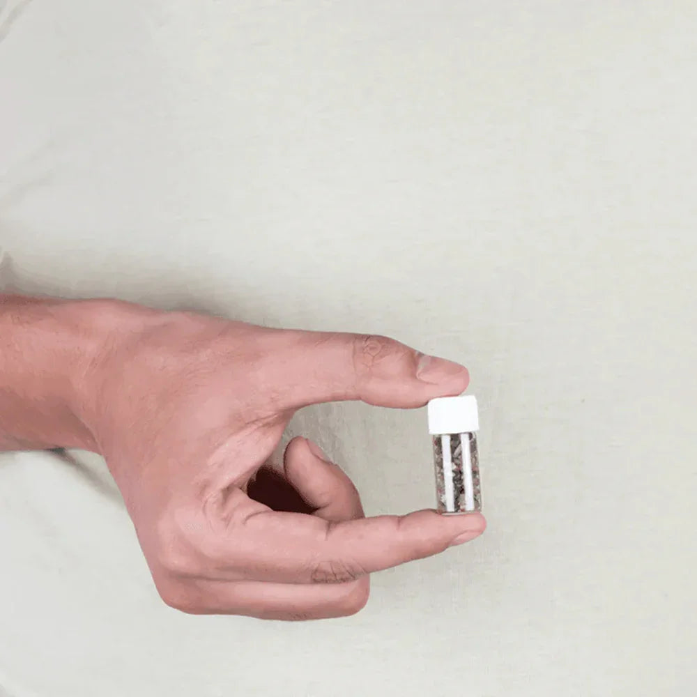 Hand holding a small MahaVastu Cat's Eye remedy bottle for Vastu Shastra balance