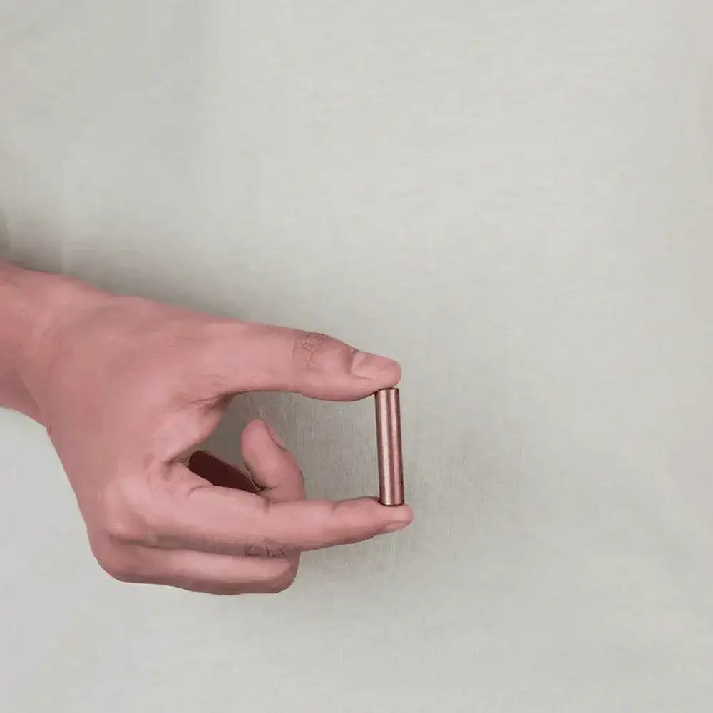 Hand holding copper Vastu metal strip for home energy balance and positivity