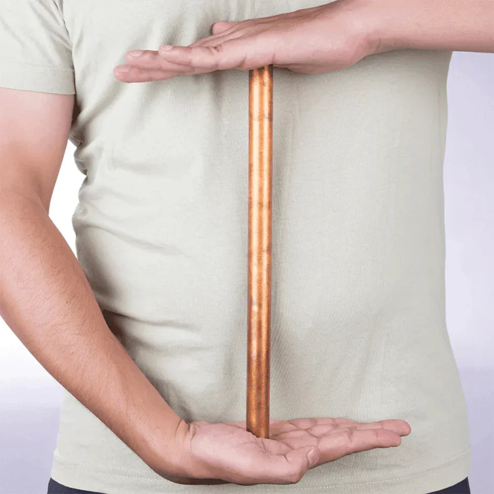 Person holding a MahaVastu copper rod remedy for Vastu Shastra balance and positivity