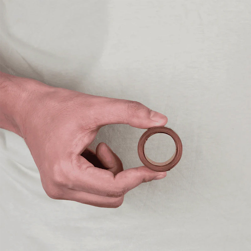 Hand holding copper Vastu tape for home energy balancing and positive vibes