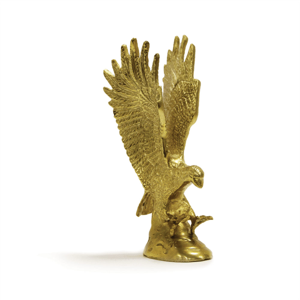 Golden eagle statue vastu remedy with wings spread, perched on a rock, displaying detailed feather textures and realistic design, shining in gold color.