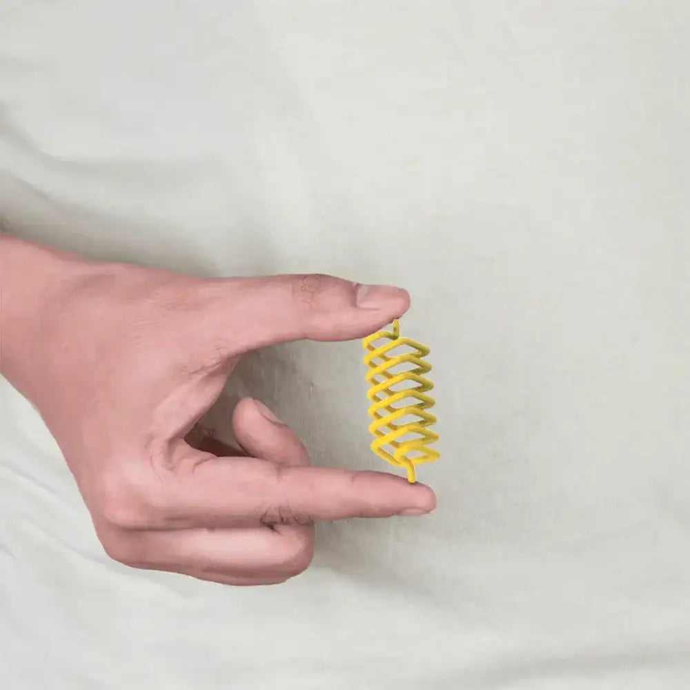 A hand holding a small yellow metal strip for Vastu remedies.