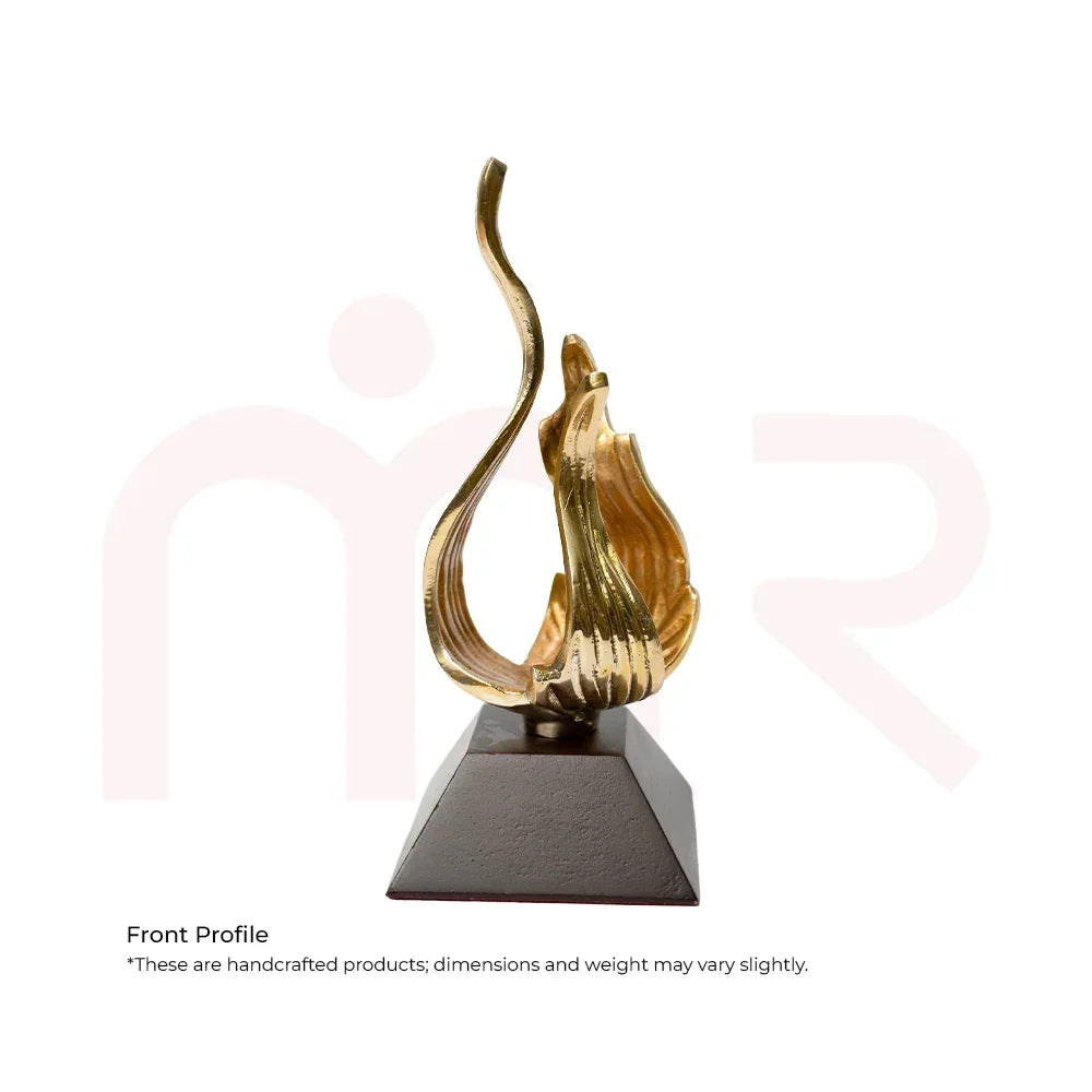 Handcrafted golden flame-shaped Vastu remedy sculpture on a black base
