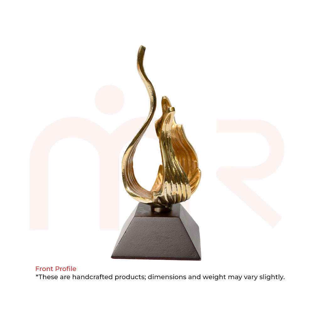 Handcrafted golden flame-shaped Vastu remedy sculpture on a black base