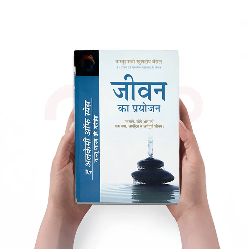 Person holding Jeevan Ka Prayojan book with Vastu Shastra theme, stack of stones on cover