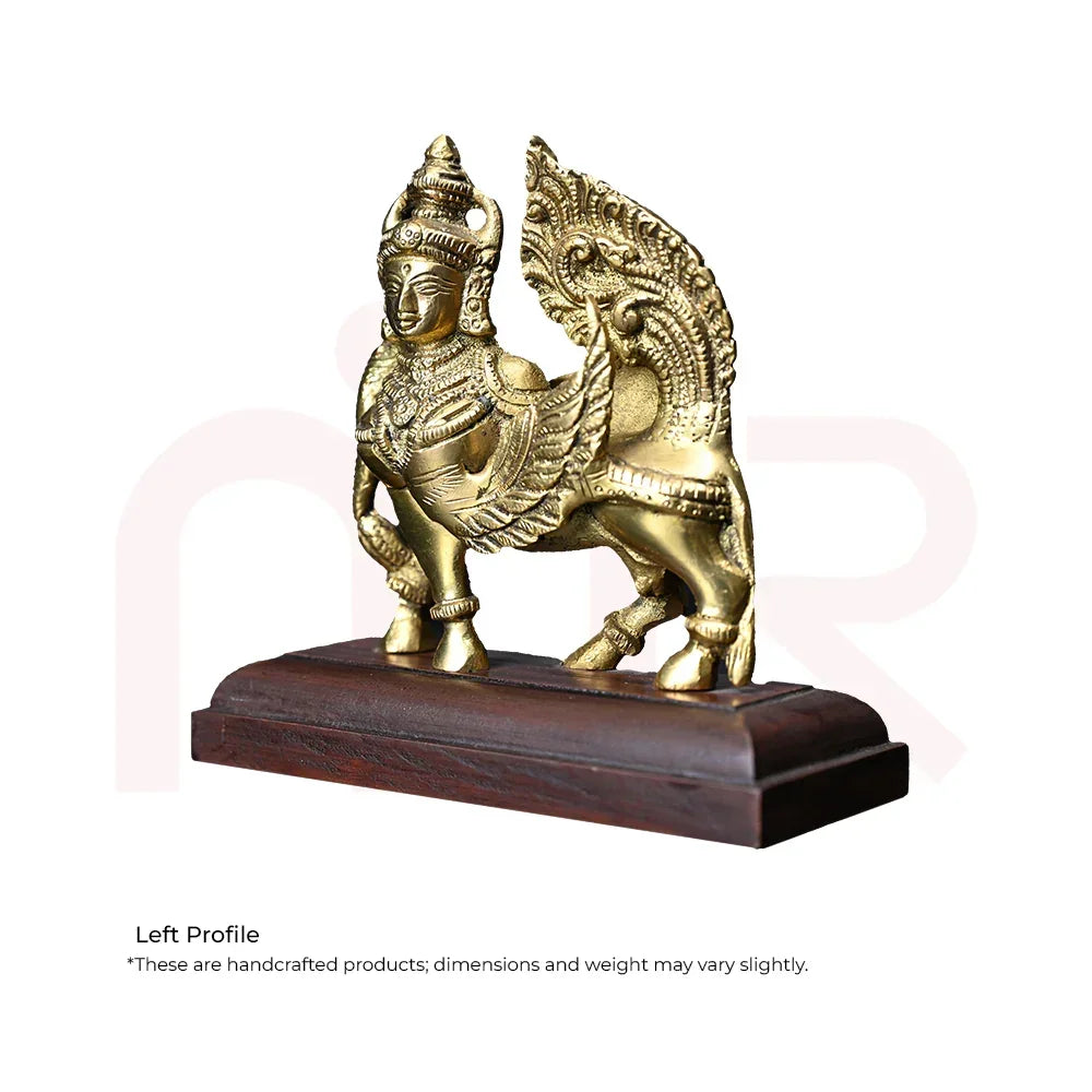 Brass Kamdhenu cow idol with ornate design, placed on wooden base for Vastu decor