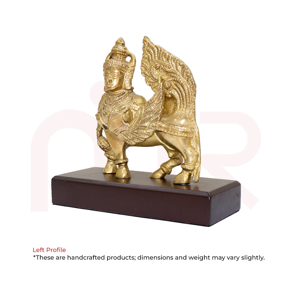 Brass Kamdhenu cow idol with ornate design, placed on wooden base for Vastu decor