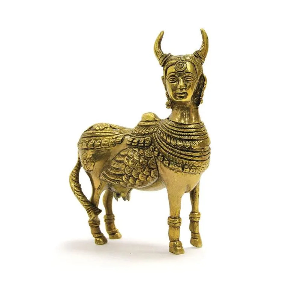 A golden color real Kamdhenu cow statue figurine with intricate detailing, in a standing position. Made in brass, this idol is placed in east south east direction 
