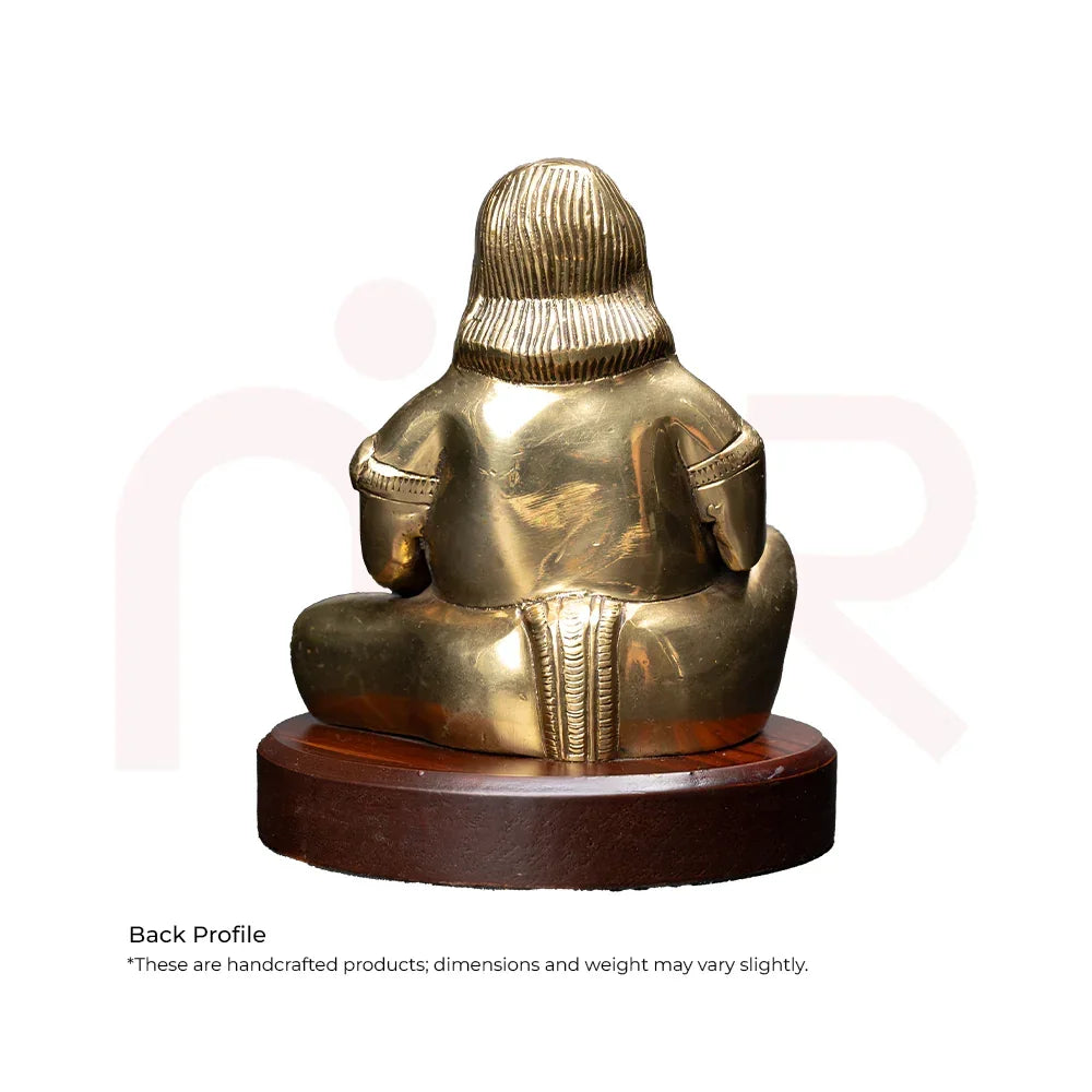 Back view of a brass Kuber idol seated on a wooden base, Vastu decorative item.