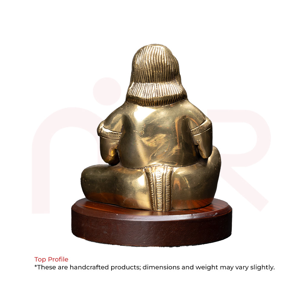 Back view of a brass Kuber idol seated on a wooden base, Vastu decorative item.
