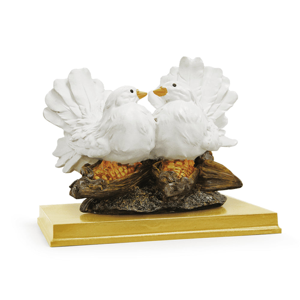 Porcelain showpiece of two white love birds, a maha vastu item, with detailed feathers and expressive eyes, perched on a textured base resembling intertwined branches, their beaks touching in a tender display, mounted on a sleek golden platform