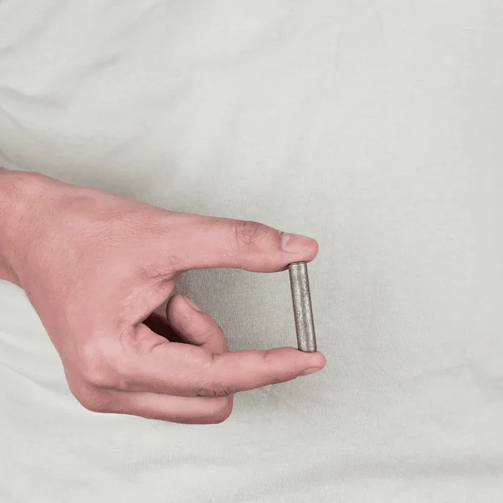 Hand holding a MahaVastu iron metal strip, Vastu Shastra remedy for positivity and balance