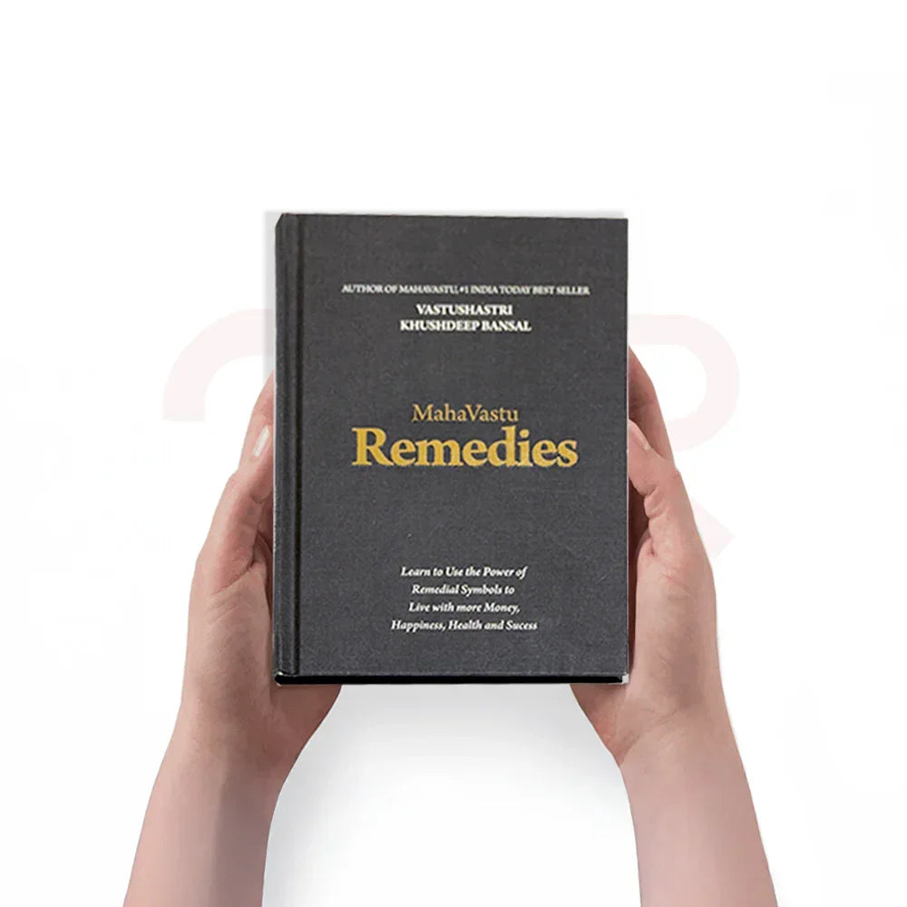 Person holding MahaVastu Remedies book on Vastu Shastra remedies for positivity and success