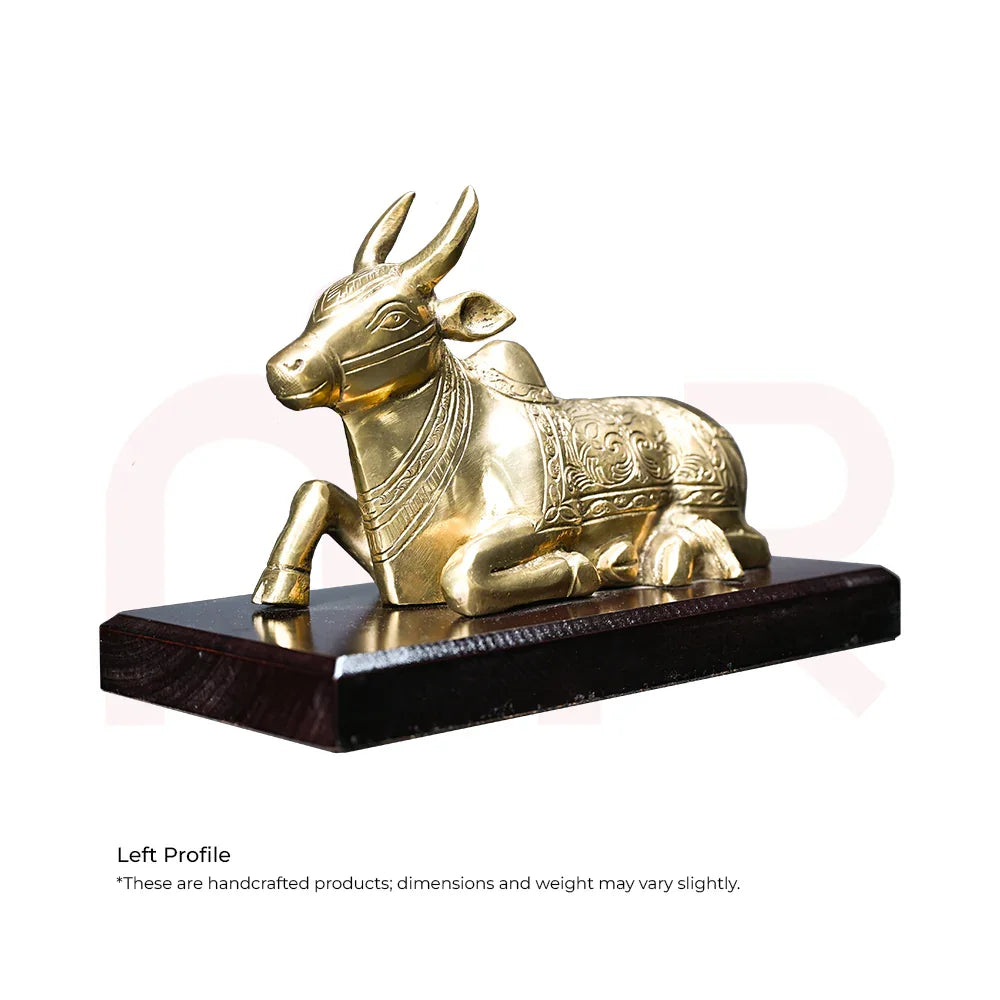 Handcrafted brass Nandi bull idol with intricate carvings on a wooden base for Vastu decor