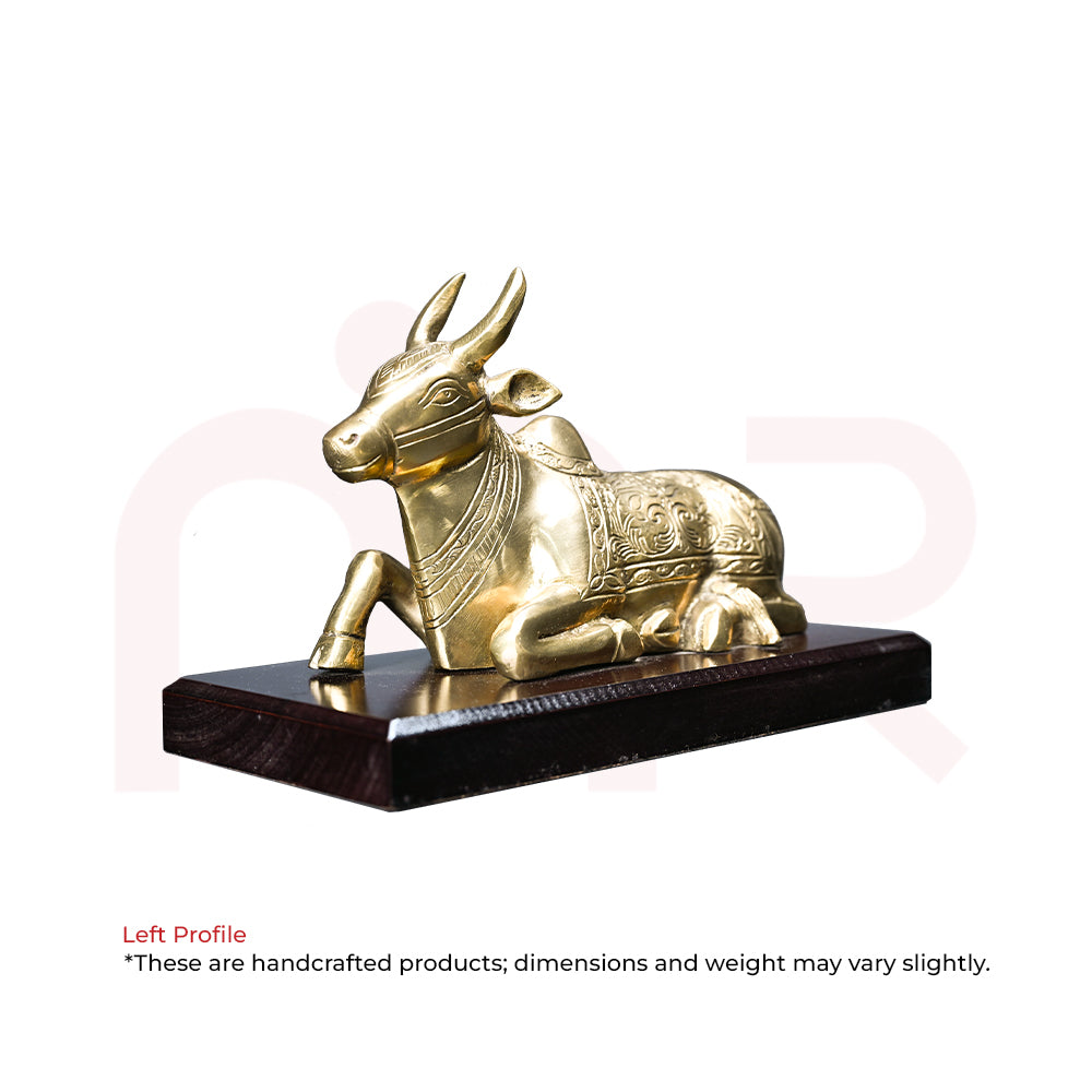 Handcrafted brass Nandi bull idol with intricate carvings on a wooden base for Vastu decor