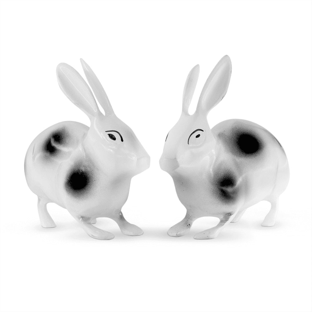Two porcelain rabbits showpiece with a glossy finish, vastu shastra remedies for east south east direction in home,   with detailed facial features, both adorned with black spots on a white body.