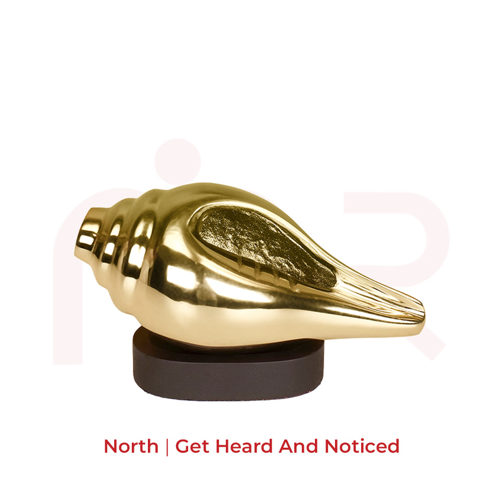 Gold shankh vastu remedy on black base for positivity and energy, isolated on white background