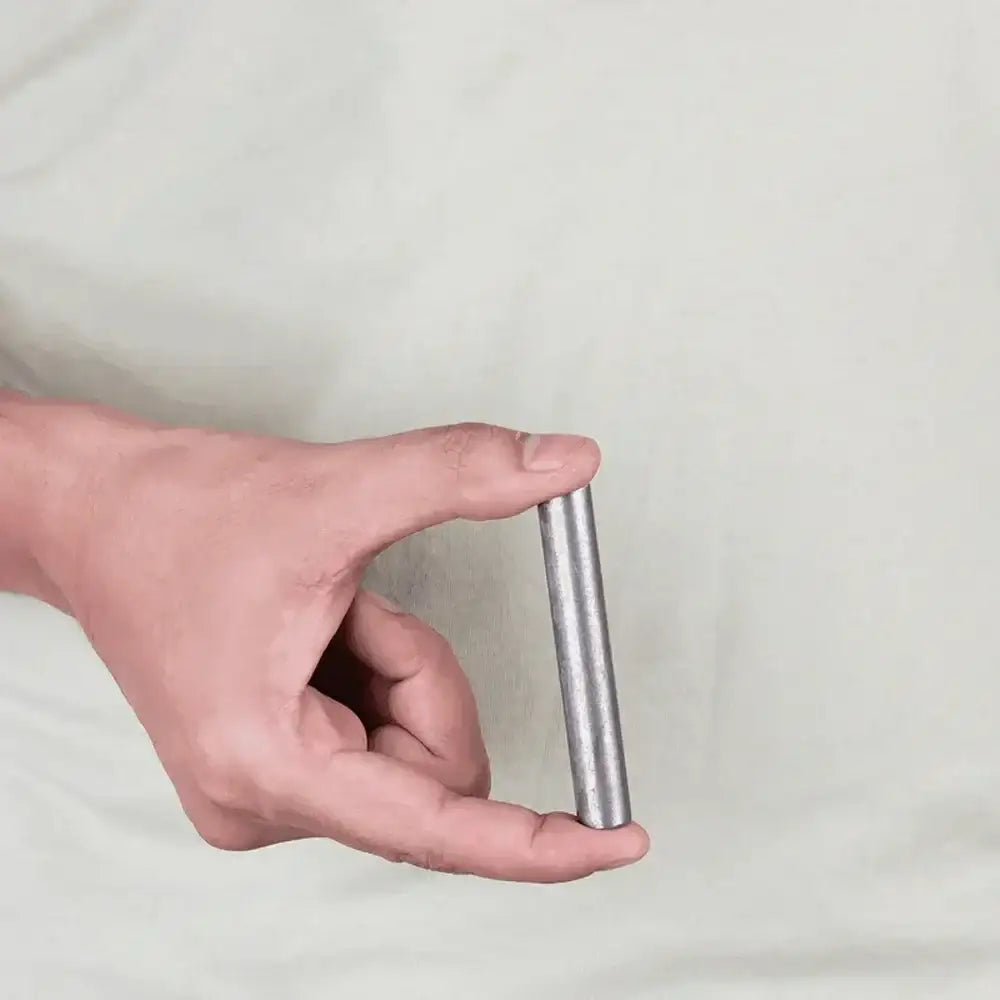 Hand holding a silver Vastu metal strip for home energy balance and positivity