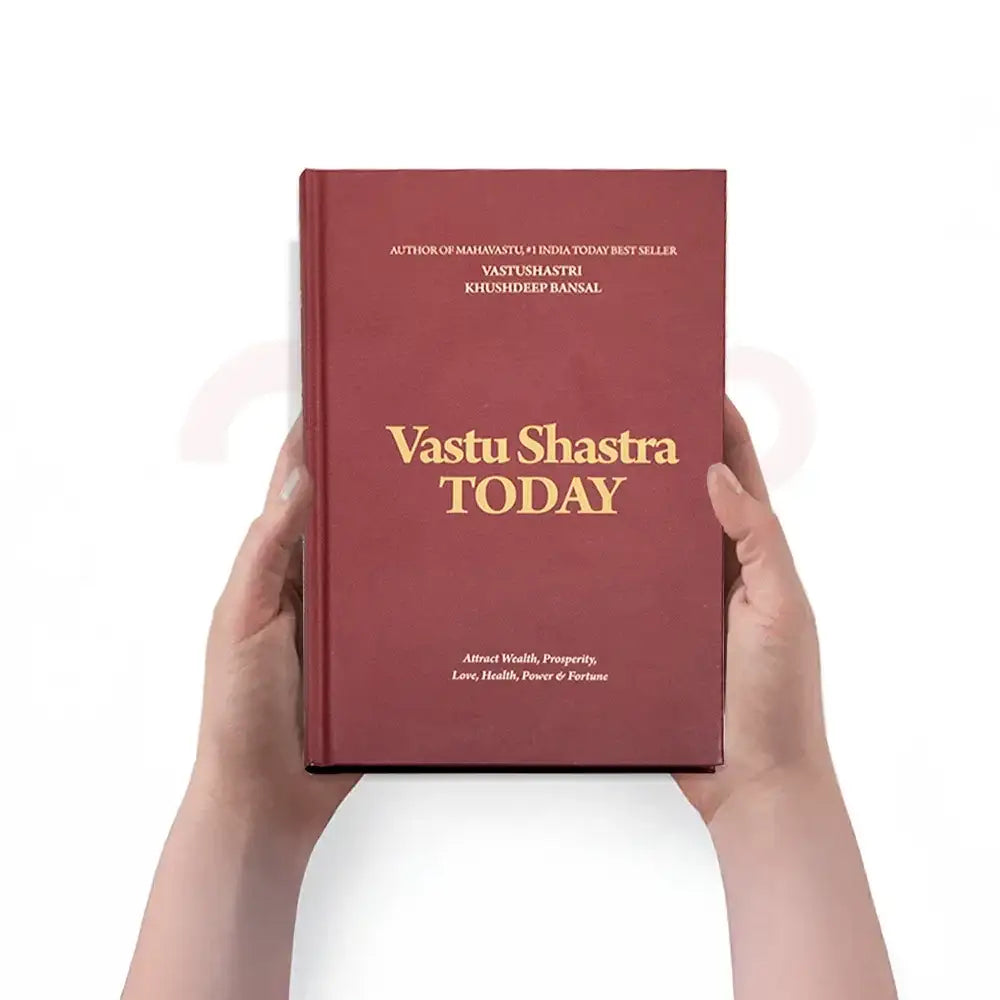Hands holding the Vastu Shastra Today book by Khushdeep Bansal for wealth and prosperity.