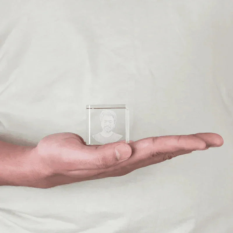 Hand holding a MahaVastu cube crystal with engraved bust, Vastu Shastra remedy product