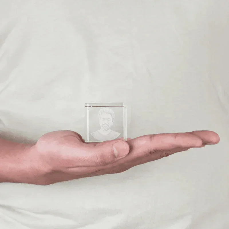 Hand holding a MahaVastu cube crystal with engraved bust, Vastu Shastra remedy product