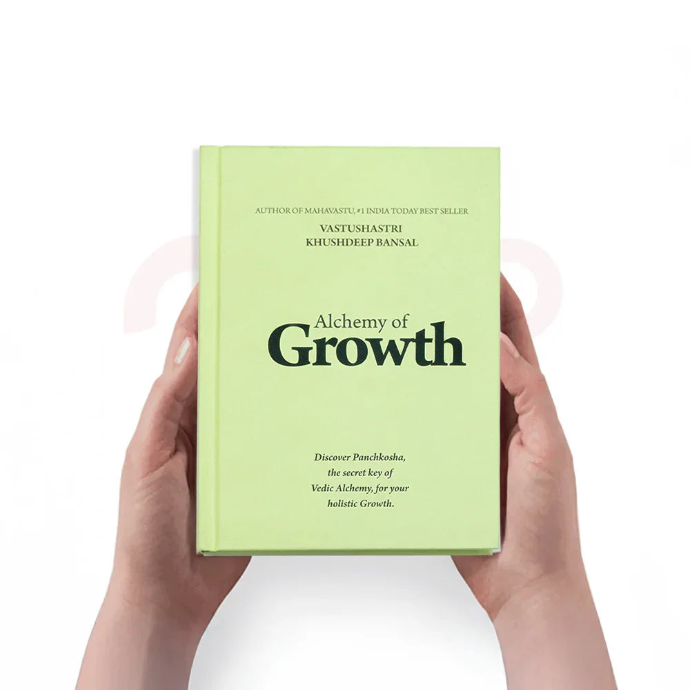 Hands holding Alchemy of Growth book on Vastu remedies and holistic growth guidance.