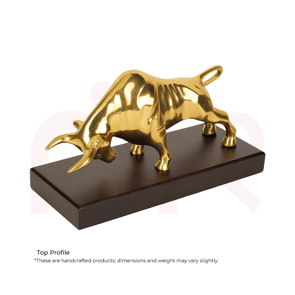 Golden charging bull statue on a dark rectangular base, symbolizing prosperity and strength.