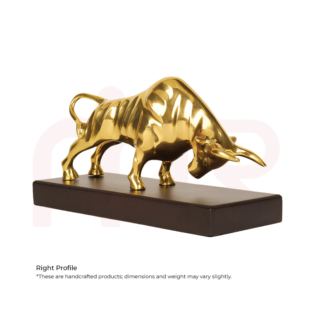 Golden charging bull statue on a rectangular base for Vastu and prosperity decor.