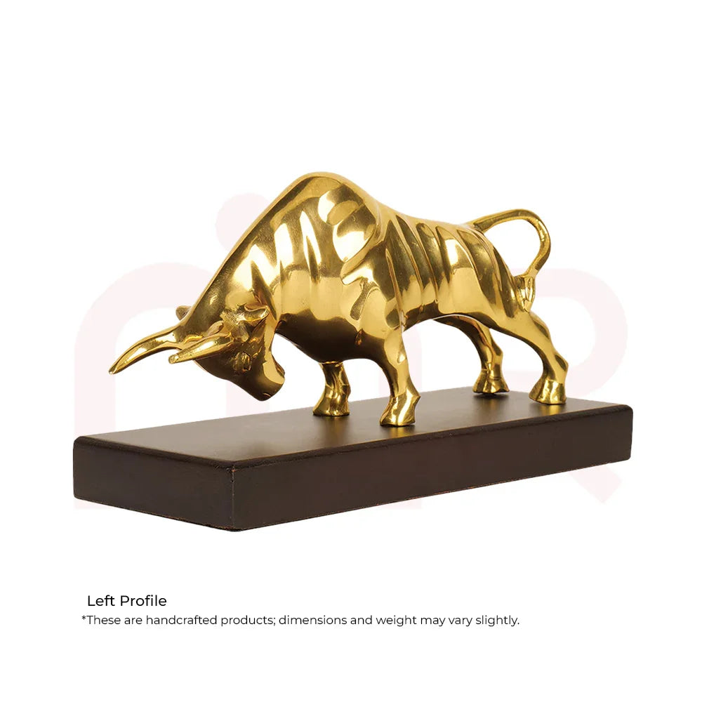 Golden charging bull statue on dark base, MahaVastu remedy for wealth and positivity