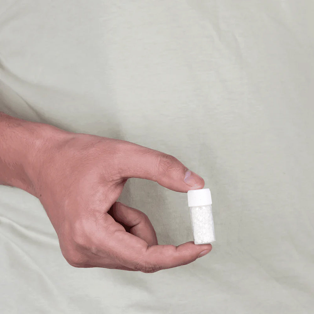 Hand holding small MahaVastu Moti remedy bottle, authentic vastu shastra product