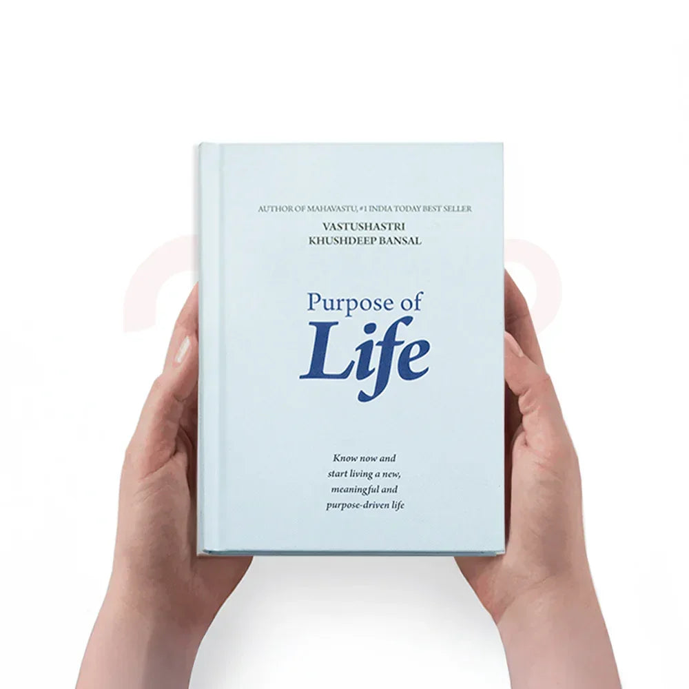 Hands holding the book 'Purpose of Life' by Vastushastri Khushdeep Bansal, white background
