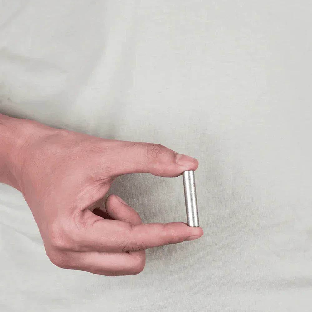 Hand holding a MahaVastu stainless steel remedy metal strip for Vastu Shastra balance